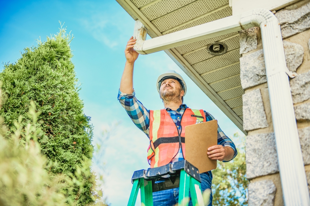 A,Man,With,Hard,Hat,Standing,On,Steps,Inspecting,House